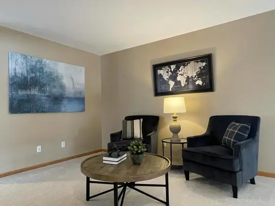 Living room professionally painted in a warm greige with a crisp white ceiling and oak trim