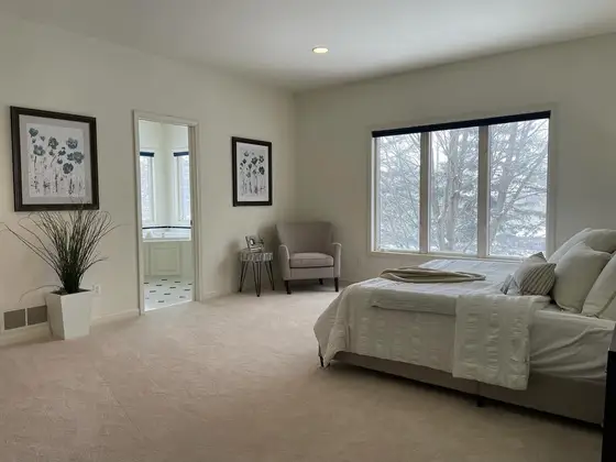Spacious master bedroom painted in a soft warm white with clean white trim