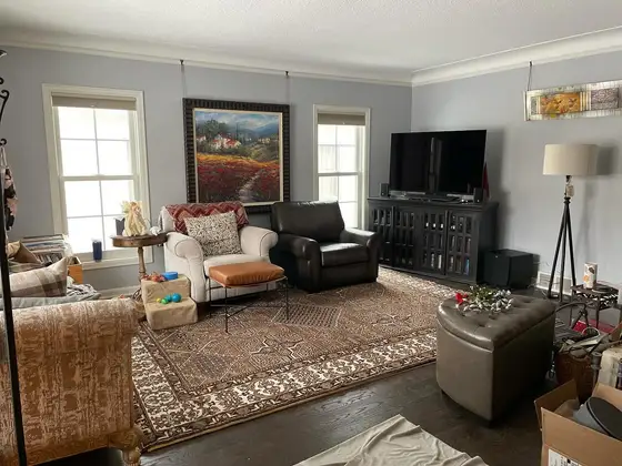 Living room painted in a calm slate blue-gray with white crown molding and window trim