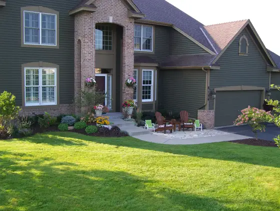Flagstone front patio with Adirondack chairs and colorful planters set into a landscaped Eden Prairie front yard